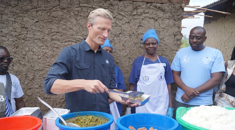 Carl Skau, acting executive director of the World Food Programme, pepares a container of food at the Rwampara Ebola treatment center in Ituri, eastern Congo, Wednesday, July 29, 2026. (AP Photo/Dieudonne Dirole)