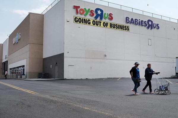 People walk by a Toys R Us store in Brooklyn on June 8, 2018 in New York City. All 735 Toys R Us stores in America are set to close by the end of June leaving  33,000 workers  without a job or  severance pay. Many of the employees losing their jobs have worked for the company for decades. Toys R Us has been owned by the private-equity giant Bain Capital.  (Photo by Spencer Platt/Getty Images)