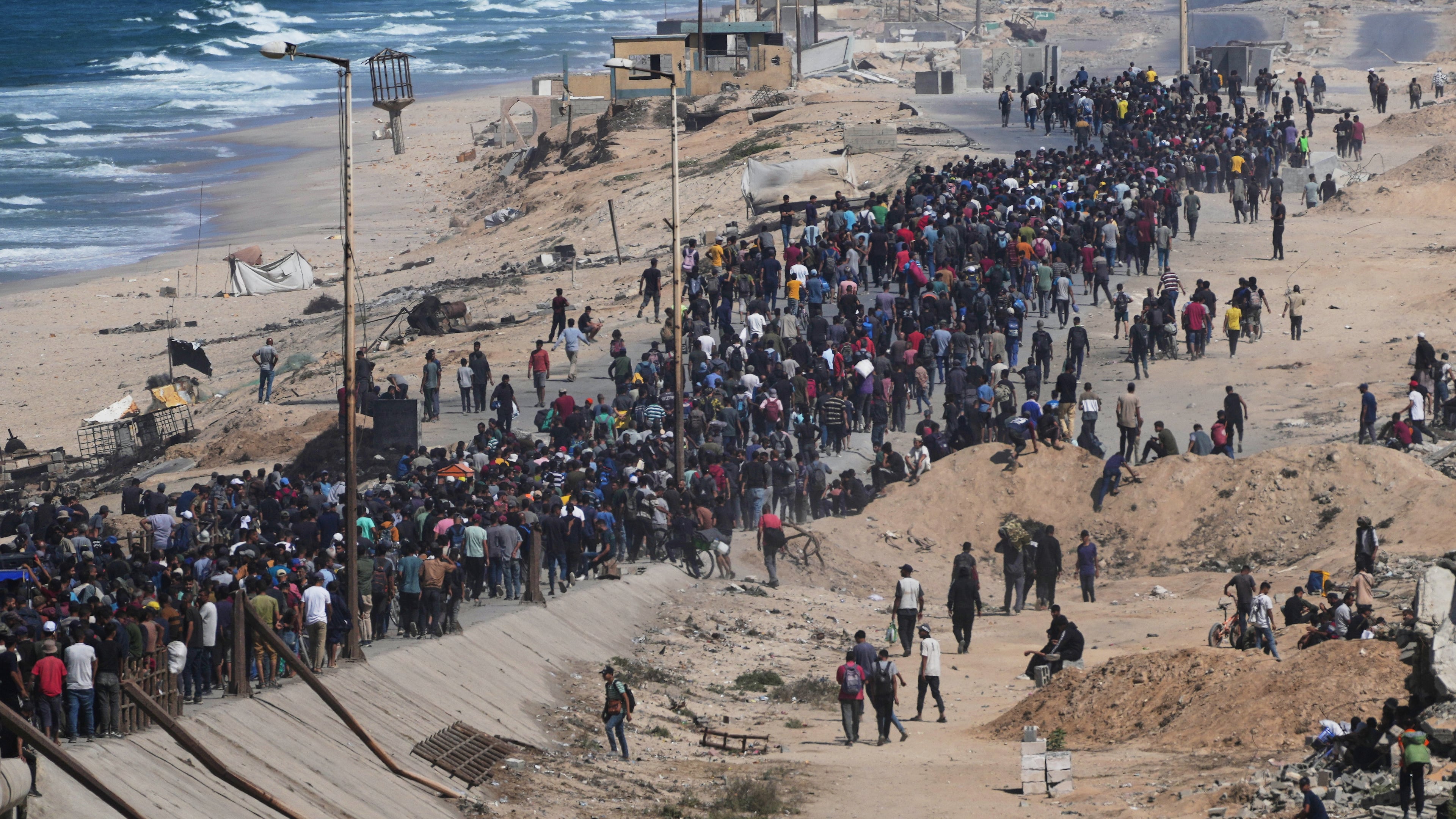 Displaced Palestinians walk along the coastal road near Wadi Gaza in the central Gaza Strip, moving toward northern Gaza, Friday, Oct. 10, 2025, after Israel and Hamas have agreed to a pause in their war and the release of the remaining hostages. (AP Photo/Abdel Kareem Hana)