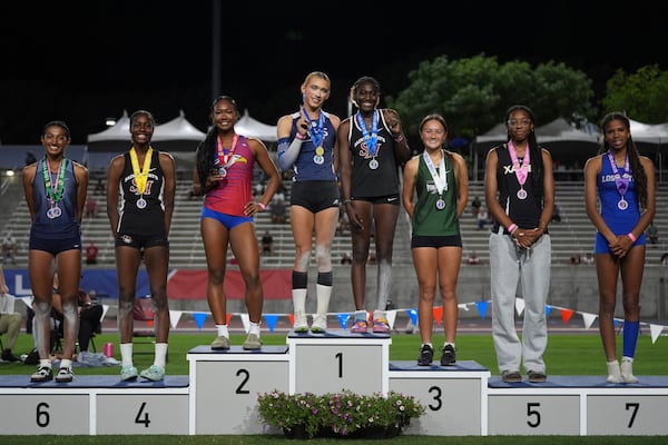 AB Hernandez, center left, shares the first-place spot on the podium with Kira Gant Hatcher during a medal ceremony for the triple jump at the California high school track-and-field championships in Clovis, Calif., Saturday, May 31, 2025. (AP Photo/Jae C. Hong)