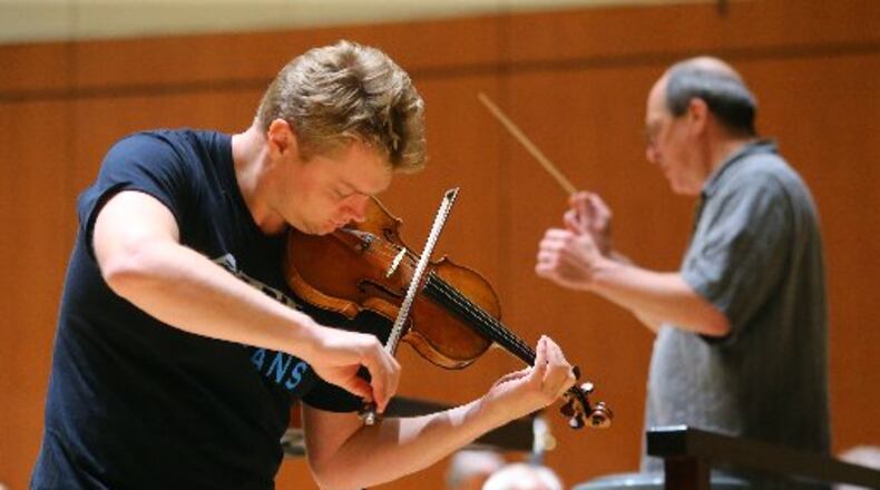 Concertmaster David Coucheron, featured soloist in the Mozart Violin Concerto No 5, and music director Robert Spano during rehearsals in preview of the opening of the Atlanta Symphony Orchestra's 70th Anniversary Season on Tuesday, Nov. 11, 2014, in Atlanta. It is the first day back in Atlanta Symphony Hall since an accord was reached on a new collective bargaining agreement. CURTIS COMPTON / CCOMPTON@AJC.COM