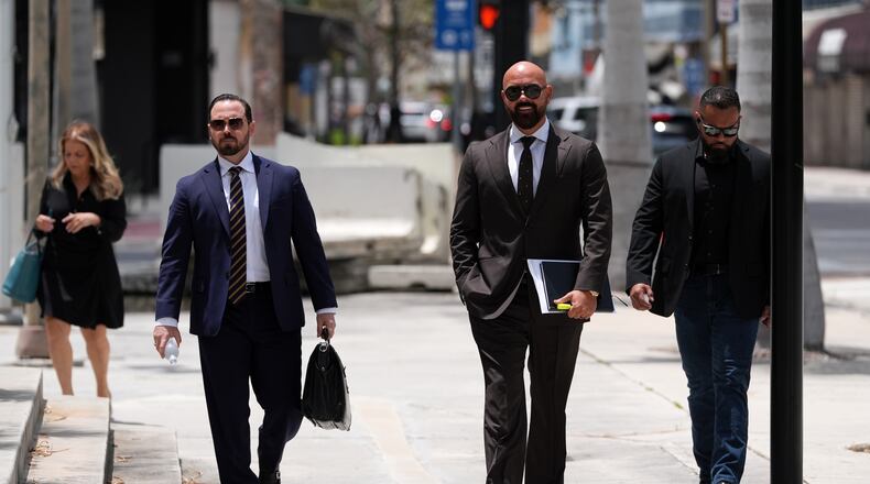 Attorney Joseph McBride, second right, representing Andrew and Tristan Tate after they were arrested to face rape and sex trafficking charges against them in the United Kingdom, arrives at the C. Clyde Atkins U.S. Courthouse, Monday, July 27, 2026, in Miami. (AP Photo/Rebecca Blackwell)