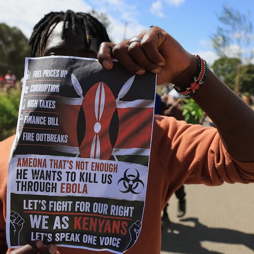 A protester holds up a placard during a demonstration against a proposed Ebola quarantine center to be established by the United States at Laikipia Air Base in Nanyuki, Kenya, Monday, June 1, 2026. (AP Photo/Andrew Kasuku)