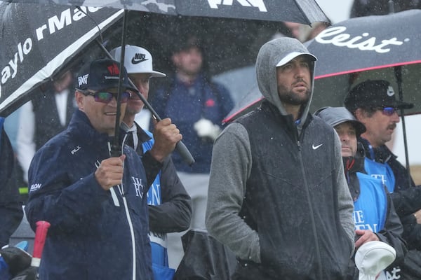 Zach Johnson of the United States , left and Scottie Scheffler of the United States wait on the 9th tee to play as rain falls during a practice round for the British Open golf championship at the Royal Portrush Golf Club, Northern Ireland, Tuesday, July 15, 2025. (AP Photo/Jon Super)