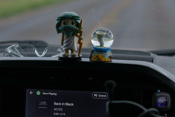 Dashboard mascots Zeus, left, and Tor, right, sit in a car as AC/DC's “Back in Black” plays on the stereo in Northern Illinois University's Husky Hail Hunter vehicle, as they drive into a storm during a Project ICECHIP operation, Friday, June 6, 2025, near Levelland, Texas. (AP Photo/Carolyn Kaster)