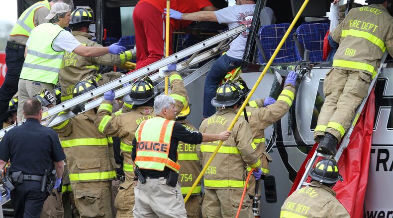 Rescue personnel work to remove passengers from a charter bus that was hit by a CSX train at the Main Street crossing in Biloxi, Miss., on Tuesday, March 7, 2017. The bus was carrying 50 people from Austin, Texas, Biloxi Police Chief John Miller said at a news conference. He said authorities believe the bus was stopped on the tracks at the time of the crash, but they don't yet know why. ( John Fitzhugh/The Sun Herald via AP)