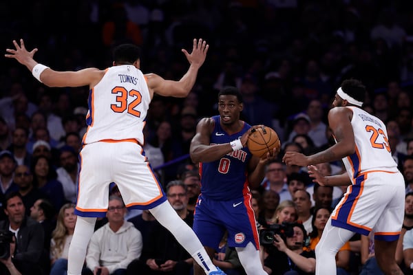 Detroit Pistons center Jalen Duren (0) looks to pass around New York Knicks center Karl-Anthony Towns (32) and Mitchell Robinson (23) during Game 5 in an NBA basketball first-round playoff series Tuesday, April 29, 2025, in New York. (AP Photo/Adam Hunger)