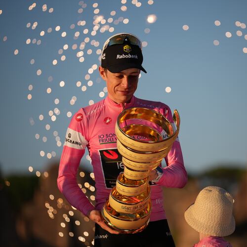 First placed Denmark's Jonas Vingegaard holds the trophy as he celebrates on the podium at the end of the Giro d'Italia cycling race in Rome Sunday, May 31, 2026. (AP Photo/Andrew Medichini)