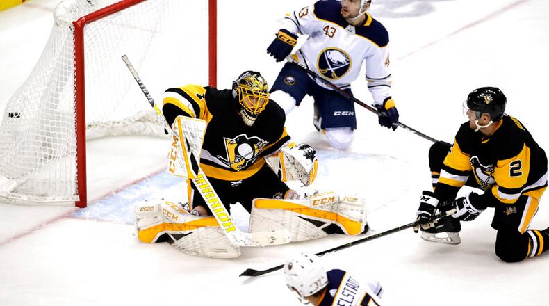 Buffalo Sabres' Conor Sheary (43) watches as shot by Casey Mittelstadt (37) gets past Pittsburgh Penguins goaltender Casey DeSmith (1) with Chad Ruhwedel (2) defending for a goal in the third period to tie an NHL hockey game in Pittsburgh, Monday, Nov. 19, 2018. The Sabres won 5-4 in overtime. During the game a deployed military member surprised his family.