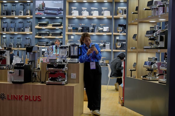 A vendor of coffee machines waits for customers at the 137th Canton Fair in Guangzhou in southern China's Guangdong province on Wednesday, April 16, 2025. (AP Photo/Ng Han Guan)