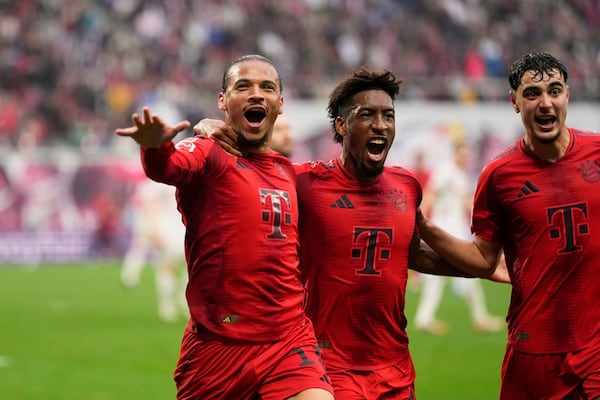 Bayern's Leroy Sane, left, celebrates with Kingsley Coman, after scoring his side's third goal during the German Bundesliga soccer match between RB Leipzig and FC Bayern Munich at the Red Bull Arena in Leipzig, Germany, Saturday, May 3, 2025. (AP Photo/Matthias Schrader)
