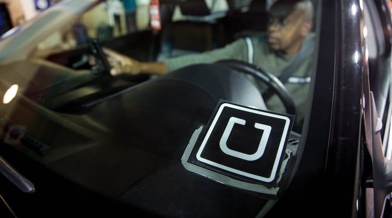 Uber driver Peter Njiru waits for his passenger at the designated rideshare area at Hartsfield-Jackson Atlanta International Airport , Monday, Jan. 2, 2017, in Atlanta. BRANDEN CAMP/SPECIAL
