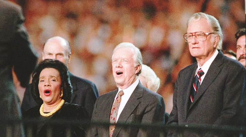 from left Coretta Scott King former President Jimmy Carter and Billy Graham stand and sing Blessed Assurance All Hail the Power at the Atlanta Billy Graham Crusade at the Georgia Dome Wednesday night About 49 800 people showed for the crusade on its first night in Atlanta Frank Niemeir Staff