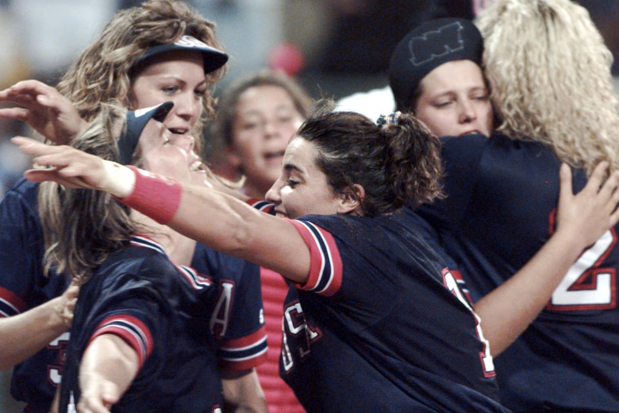 Dot Richardson (left) hugs Lisa Fernandez as Michele Smith (behind Dot) gets ready to celebrate the Americans' win of the first gold medal in the sport of softball on July 30, 1996, during the 1996 Summer Olympics in Columbus. (Renee Hannans/AJC)