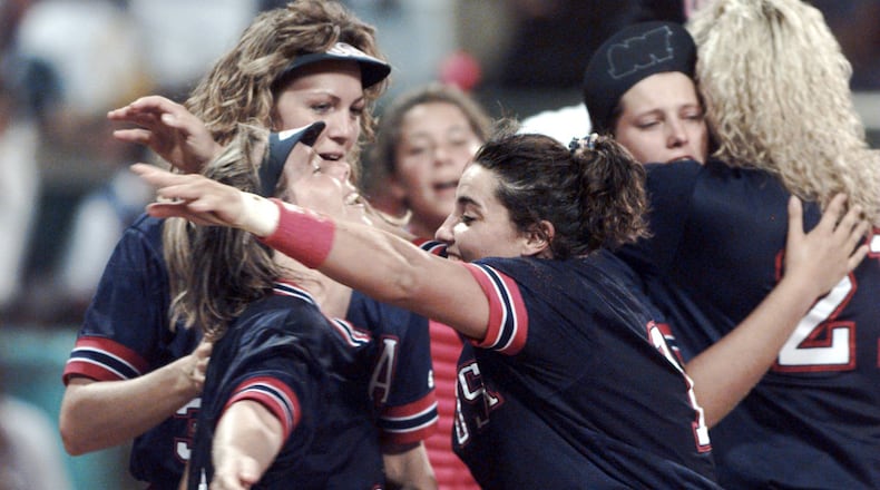Dot Richardson (left) hugs Lisa Fernandez as Michele Smith (behind Dot) gets ready to celebrate the Americans' win of the first gold medal in the sport of softball on July 30, 1996, during the 1996 Summer Olympics in Columbus. (Renee Hannans/AJC)