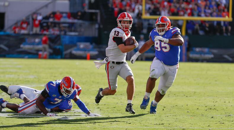 Georgia Bulldogs quarterback Stetson Bennett (13) scrambles for a first and goal during the first half of the annual NCCA Georgia vs. Florida game at TIAA Bank Field in Jacksonville. Bob Andres / bandres@ajc.com