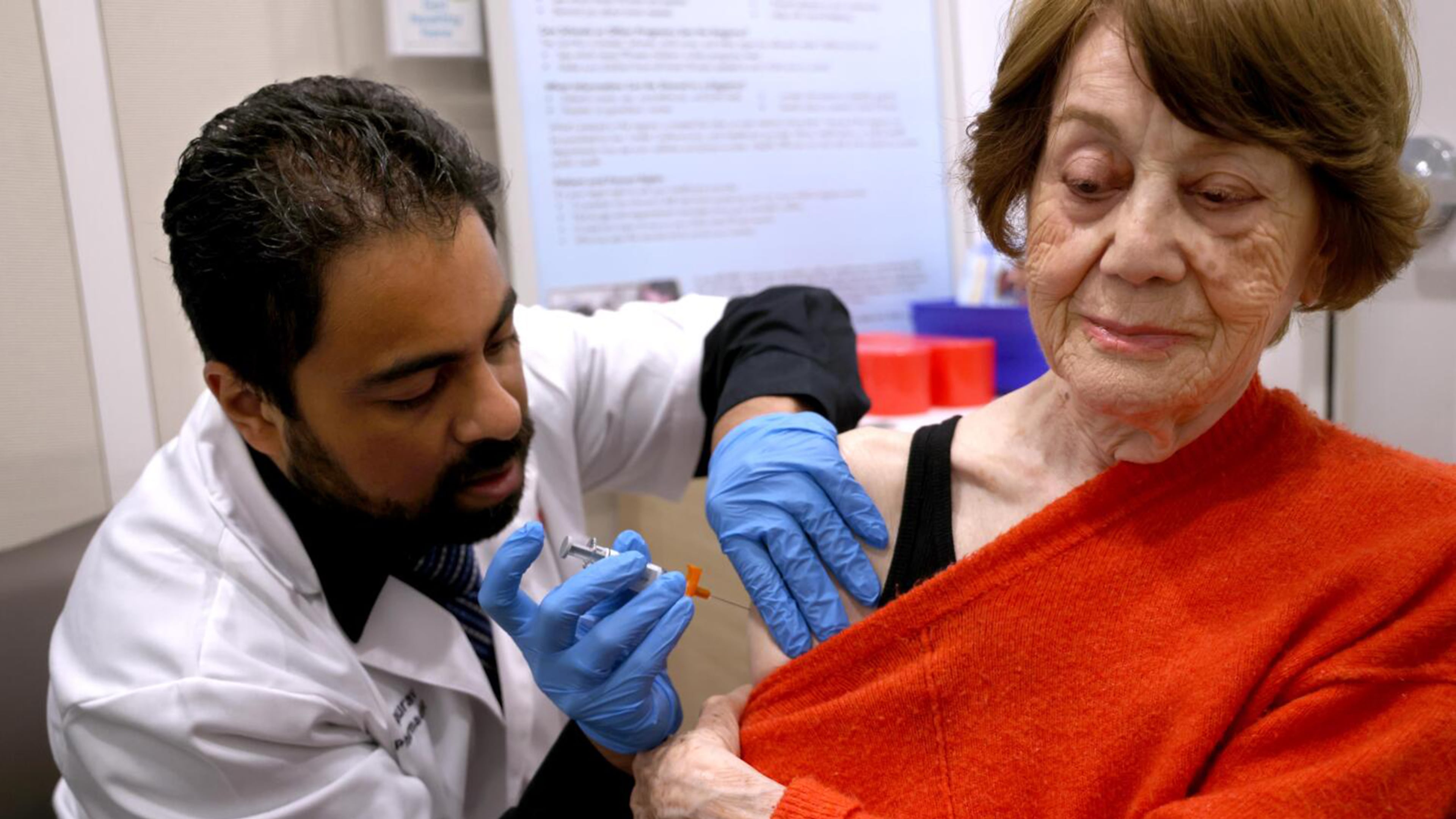 Dr. Gaurav Shinde (left) gives Giti Noroozi, 85, vaccinations for COVID and the flu at a California pharmacy in 2024. It is recommended that older adults get flu shots, as they are at a higher risk for hospitalization or death from the flu. (Genaro Molina/TNS 2024)