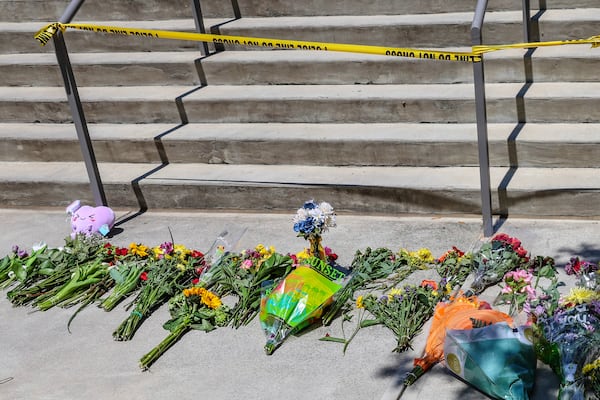 Flowers placed by students sit near police tape near the Florida State Student Union building, Tallahassee, Fla., Friday, April 18, 2025. (AP Photo/Gary McCullough)