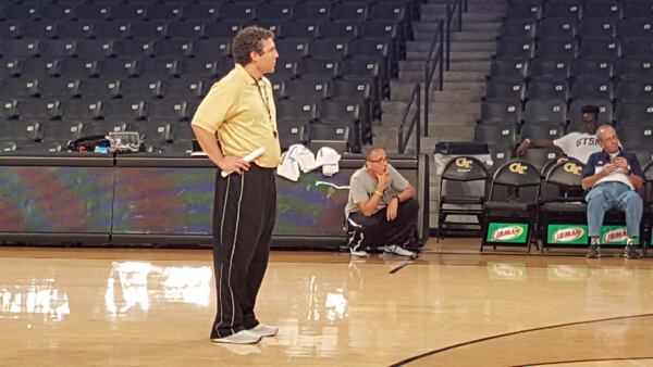 Ron Bell, kneeling in the background, watches Georgia Tech’s basketball team practice in 2016. Bell, a reformed prescription-drug addict and former prison inmate, befriended coach Josh Pastner, standing in the foreground, gaining remarkable access to Pastner’s teams and his family. Then their relationship dissolved amid allegations of NCAA violations, blackmail and sexual assault. Photo courtesy of Ron Bell.