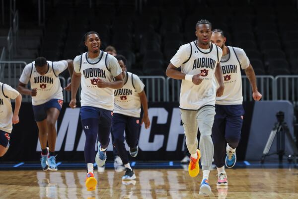Auburn guard Miles Kelly (right, a Stone Mountain native and three-year Georgia Tech player) warms up with teammates at State Farm Arena on Thursday.