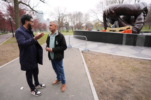 Wayne Lucas, right, who sixty years ago participated at the Freedom Rally on Boston Common, talks with Imari Paris Jeffries, the president and CEO of Embrace Boston, at the "The Embrace" sculpture on the common, Tuesday, April 15, 2025, in Boston. (AP Photo/Charles Krupa)
