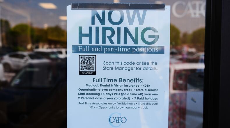 A now hiring sign sits on the window of a retail clothing store in Garland, Texas, Monday, March 23, 2026. (AP Photo/LM Otero)