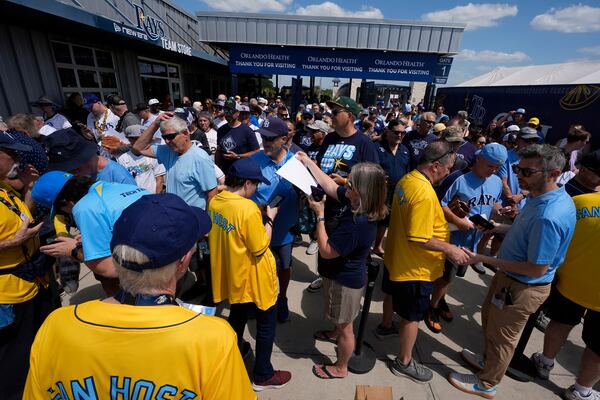 Baseball fans gets their tickets scanned as they enter Steinbrenner Field before a baseball game between the Tampa Bay Rays and the Colorado Rockies Friday, March 28, 2025, in Tampa, Fla. (AP Photo/Chris O'Meara)