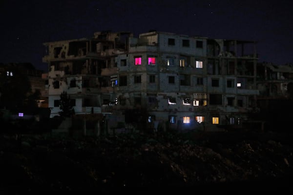 FILE - Lights illuminate a few windows of a damaged building in Damascus, Syria, early Thursday, March 27, 2025. (AP Photo/Omar Sanadiki, File)