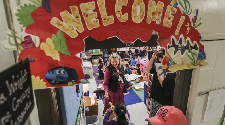 Kindergarten teacher Nell Wright welcomes students on their first day of class at Cobb County’s Argyle Elementary School in Smyrna. JOHN SPINK /JSPINK@AJC.COM