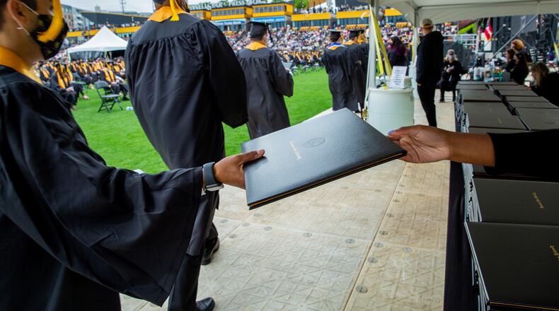 Kennesaw State University holds graduation Wednesday May 12, 2021 at the college’s stadium.  Graduates are handed diplomas during the ceremony but will receive their specific diploma after graduation.   (Jenni Girtman for The Atlanta Journal Constitution)
