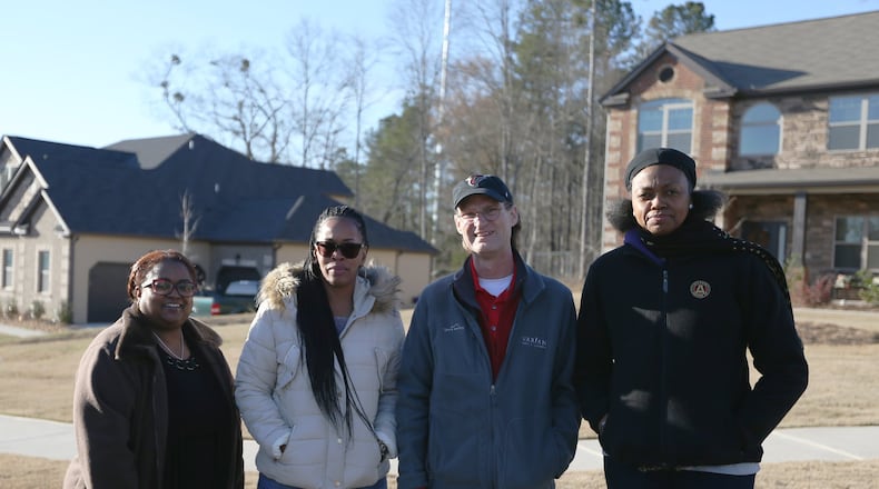 3/6/19 - Stonecrest - Katrina Langford, left, Lynn Goodwin, Phillip Kelly and Virginia Kelly pose for a portrait with the cell tower that was put up right by his home in Stonecrest, Georgia on Wednesday, March 6, 2019. The cell tower was improperly built due to a zoning quirk. Residents were not informed and are trying to get the tower removed. EMILY HANEY / emily.haney@ajc.com