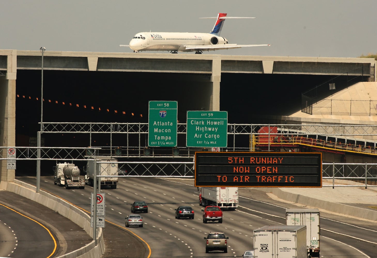 060527 - RIVERDALE, GA: A Delta plane rolls over the 5th runway bridge as cars continue to move on Interstate 285. The runway  opened to air traffic on May 27, 2006. (AJC file photo)