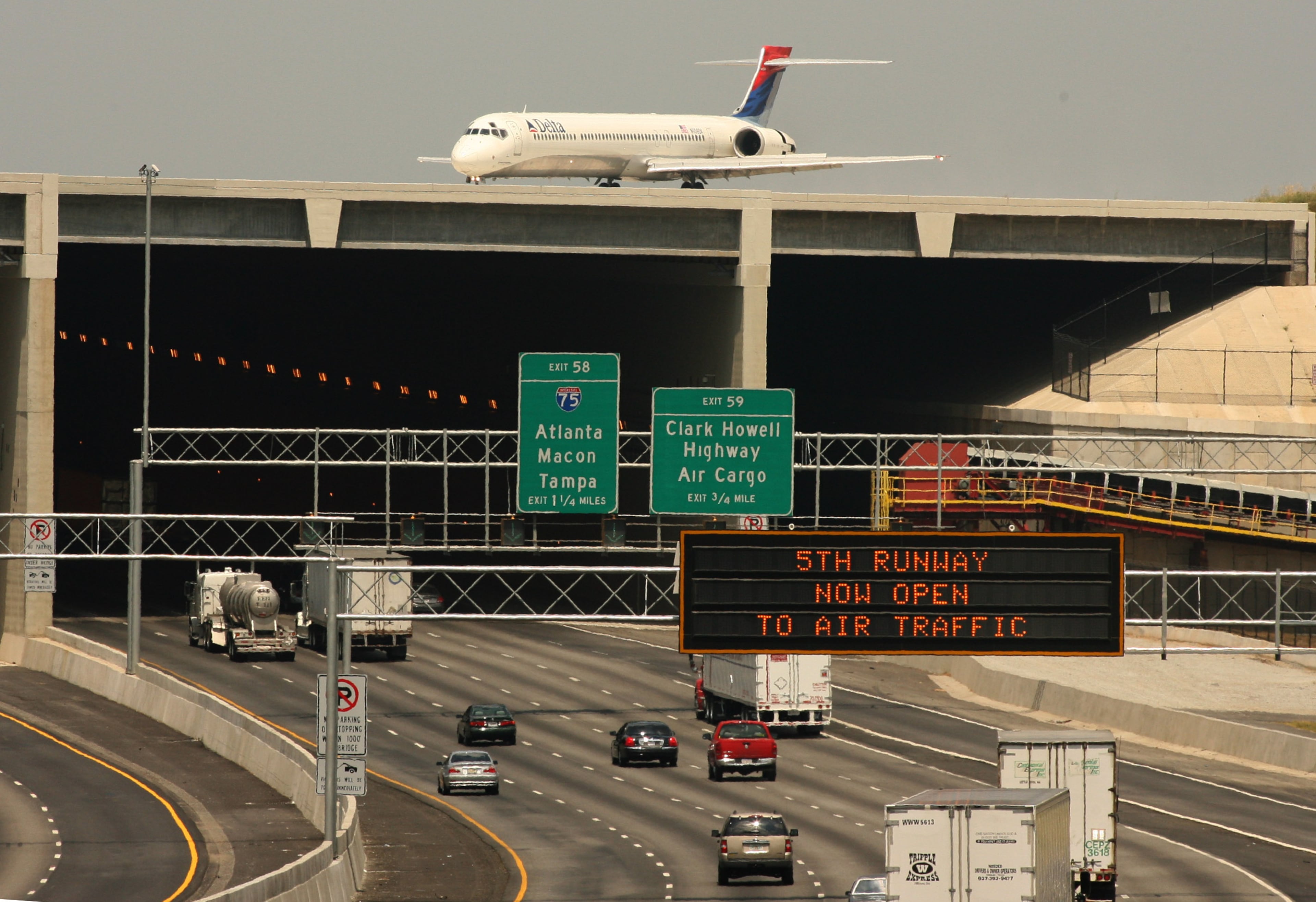 060527 - RIVERDALE, GA: A Delta plane rolls over the 5th runway bridge as cars continue to move on Interstate 285. The runway opened to air traffic on May 27, 2006. (AJC file photo)