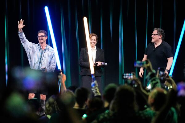 From left, actors Pedro Pascal and Sigourney Weaver react to audience members as director Jon Favreau looks on during a fan convention called the Star Wars Celebration Japan in Chiba, near Tokyo, Friday, April 18, 2025. (AP Photo/Hiro Komae)