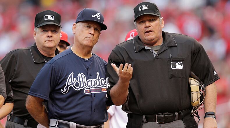 Home plate umpire Hunter Wendelstedt points out the eccentricities of Busch Stadium to Braves interim manager Brian Snitker prior to the Braves' baseball game against the St. Louis Cardinals, Friday, Aug. 5, 2016, in St. Louis.
