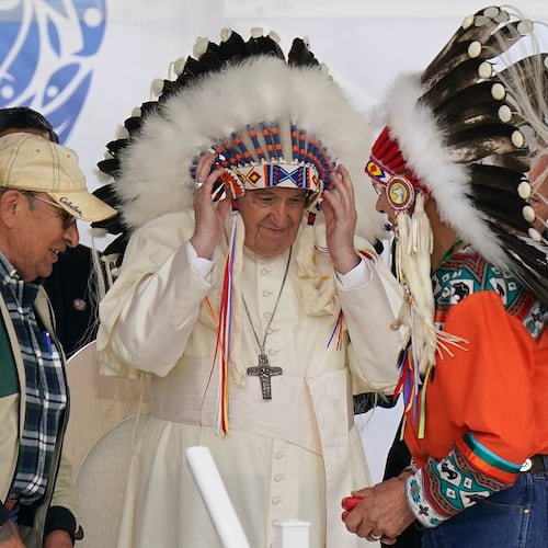 FILE - Pope Francis dons a headdress during a visit with Indigenous peoples at Maskwaci, the former Ermineskin Residential School, Monday, July 25, 2022, in Maskwacis, Alberta. (AP Photo/Eric Gay, File)