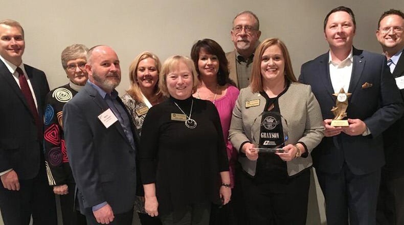 Grayson city leaders accept Live, Work, Play City Award. Left to right: Chip Mitchell, Grayson DDA Chairman; Linda Jenkins, Council Member; Steve Sappington, City Planner; Laurie Anderson, Council Member; Gail Lane, Community Development Director; Laura Cone, City Administrator; James Gillespie, Council Member; Allison Wilkerson, Mayor; Chris Banks, Grayson Cycling Club (holding Most Active City in Georgia Award); Paul Hoover, Architect.