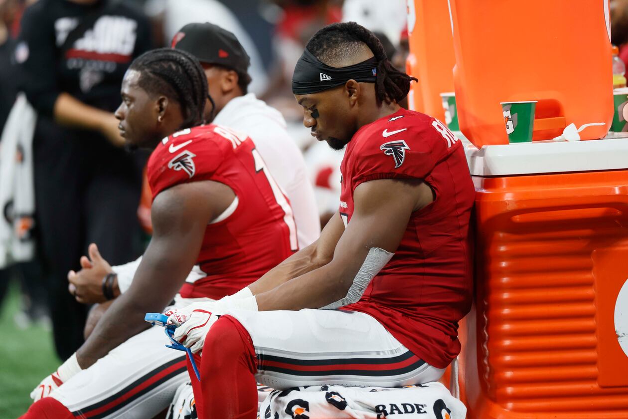 Atlanta Falcons players, including running back Bijan Robinson (7), look down during the second half of an NFL game against the Carolina Panthers at Mercedes-Benz Stadium in Atlanta on Sunday, Sept. 20, 2026. (Miguel Martinez/AJC)