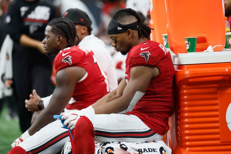 Atlanta Falcons players, including running back Bijan Robinson (7), look down during the second half of an NFL game against the Carolina Panthers at Mercedes-Benz Stadium in Atlanta on Sunday, Sept. 20, 2026. (Miguel Martinez/AJC)