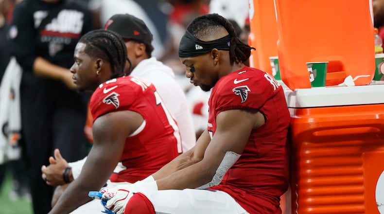 Running back Bijan Robinson (right) and other Falcons players sit on the bench during the second half of a blowout against the Panthers on Sunday, Sept. 20, 2026, at Mercedes-Benz Stadium in Atlanta. (Miguel Martinez/AJC)
