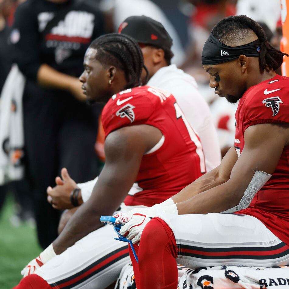 Running back Bijan Robinson (right) and other Falcons players sit on the bench during the second half of a blowout against the Panthers on Sunday, Sept. 20, 2026, at Mercedes-Benz Stadium in Atlanta. (Miguel Martinez/AJC)