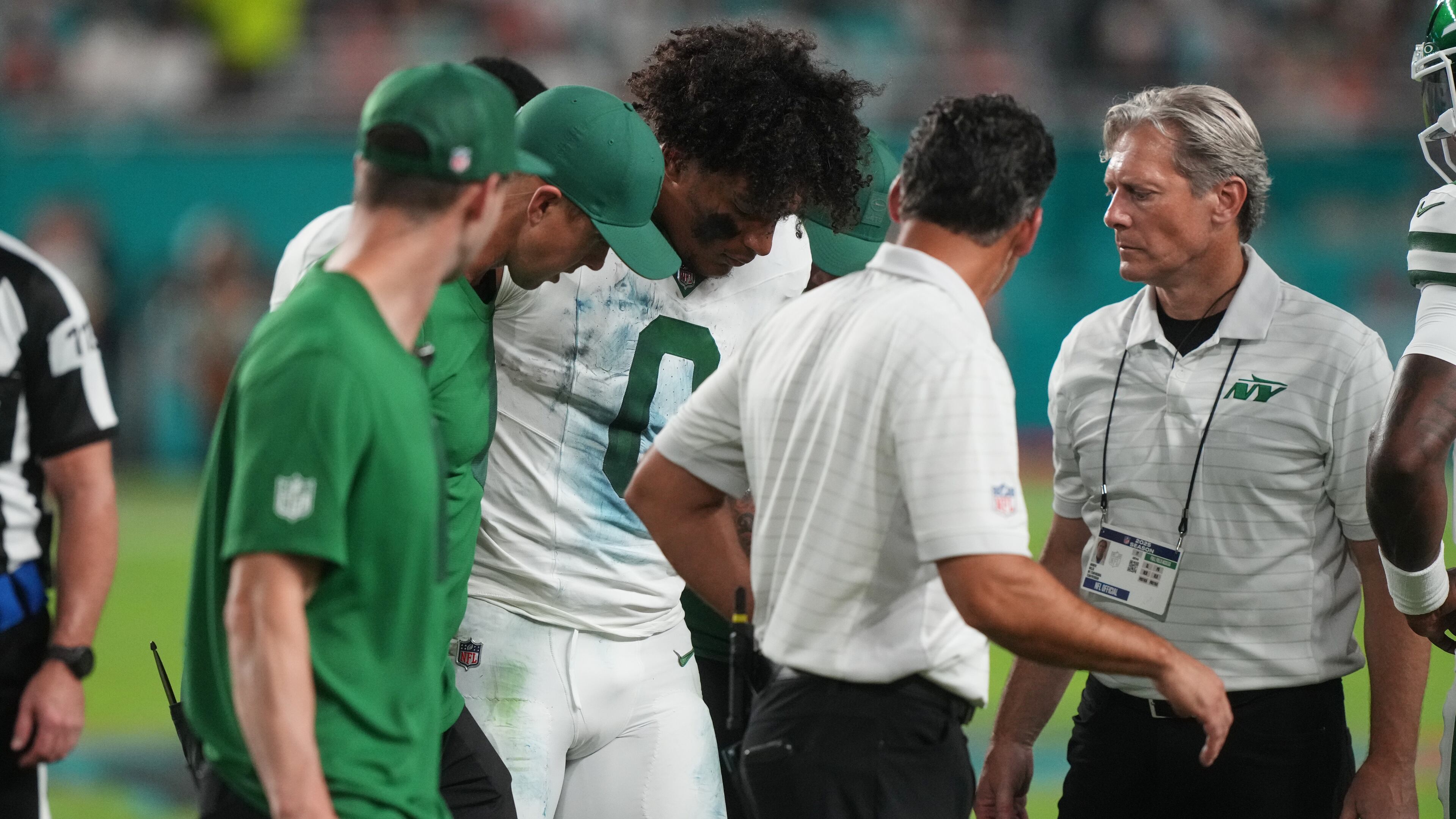 New York Jets running back Braelon Allen (0) walks off the field with team staff after suffering an unknown injury in the first half of an NFL football game against the Miami Dolphins, Monday, Sept. 29, 2025, in Miami Gardens, Fla. (AP Photo/Marta Lavandier)