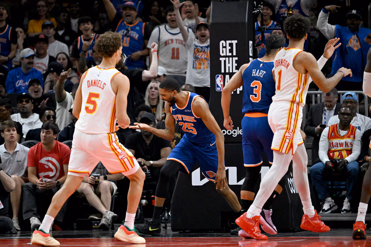 Knicks guard Mikal Bridges (center), flanked by the Hawks’ Dyson Daniels (left) and Jalen Johnson, celebrates after dunking the ball during Game 6 of the first-round Eastern Conference series at State Farm Arena on Thursday, April 30, 2026, in Atlanta. (Hyosub Shin/AJC)