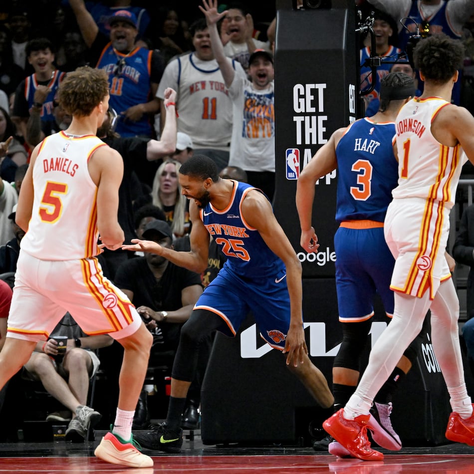 Knicks guard Mikal Bridges (center), flanked by the Hawks’ Dyson Daniels (left) and Jalen Johnson, celebrates after dunking the ball during Game 6 of the first-round Eastern Conference series at State Farm Arena on Thursday, April 30, 2026, in Atlanta. (Hyosub Shin/AJC)