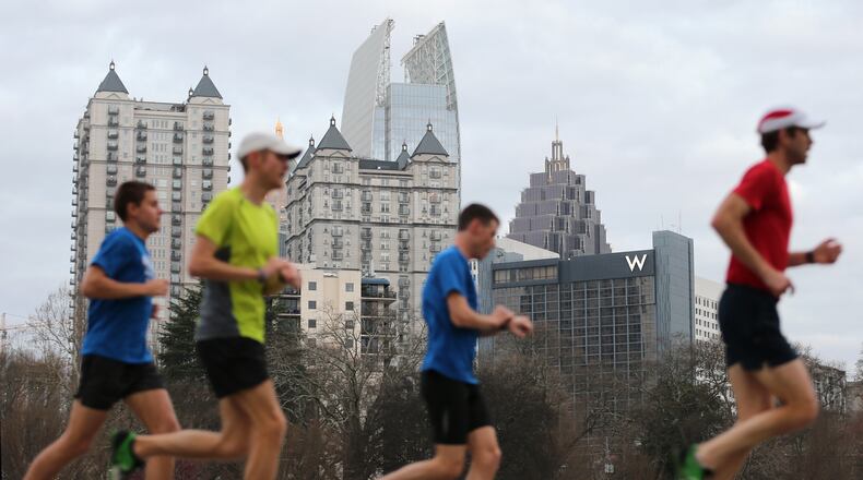 Runners take advantage of the unseasonably warm weather Wed., March 9, 2016, as they run past the Midtown skyline on the Active Oval in Piedmont Park. BEN GRAY / BGRAY@AJC.COM