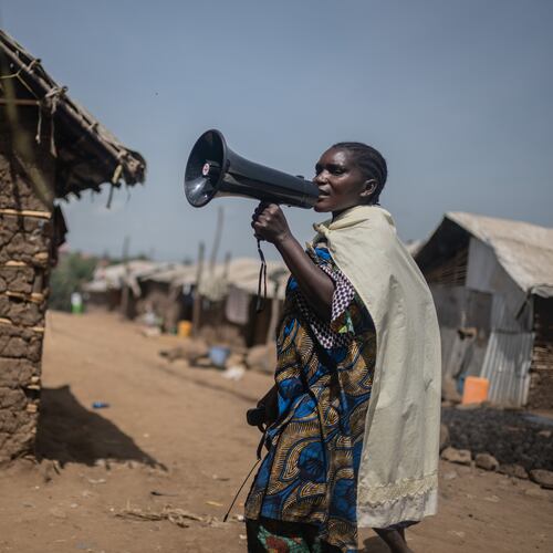 Machozi Naumi, 45, raises awareness of Ebola in the camp on the property of the city's ISP (Institut Supérieur Pédagogique), where internally displaced people reside in Bunia, Congo, Tuesday, May 26, 2026. (AP Photo/Moses Sawasawa)