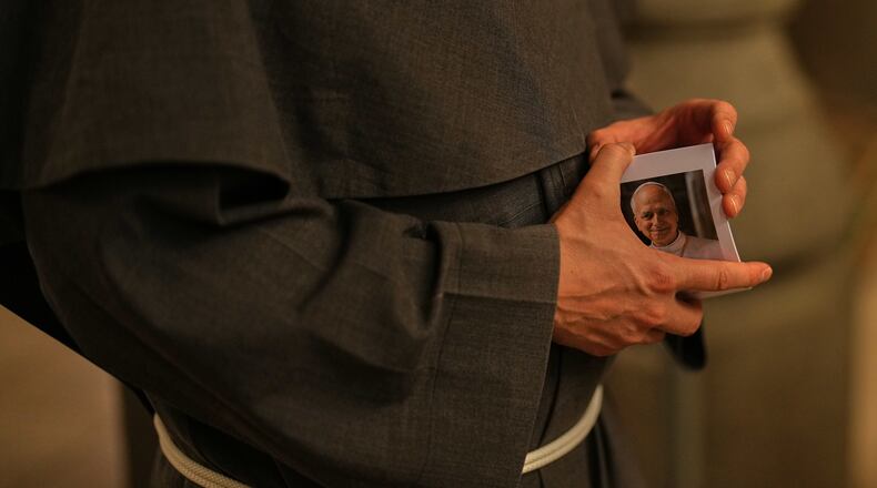 Christian Catholic priest Father Andrew holds photographs of Pope Leo XIV following a mass at St. Anthony of Padua Catholic church, in Istanbul, Turkey, Tuesday, Nov. 18, 2025, ahead of the visit of Pope Leo XIV to Turkey. (AP Photo/Francisco Seco)