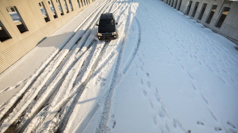 A car drives on a parking deck covered in snow at Kennesaw State University on Sunday, Dec. 10, 2017.