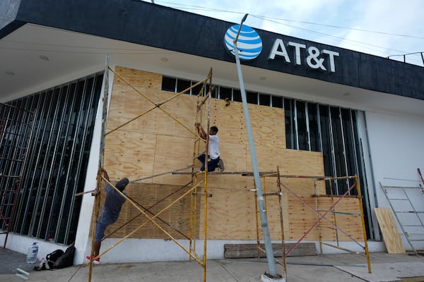 Workers board up a storefront as they prepare for the arrival of Hurricane Erick, in Acapulco, Mexico, Wednesday, June 18, 2025. (AP Photo/Fernando Llano)