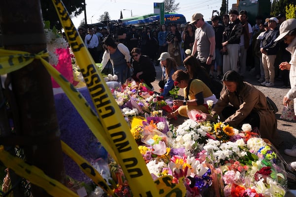 Visitors pay their respects at a memorial after a vehicle drove into a crowd during a Filipino heritage festival in Vancouver, British Columbia, Sunday, April 27, 2025. (AP Photo/Lindsey Wasson)